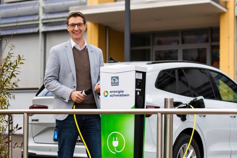 Mann mit Ladekabel vor Ladesäule energie schwaben