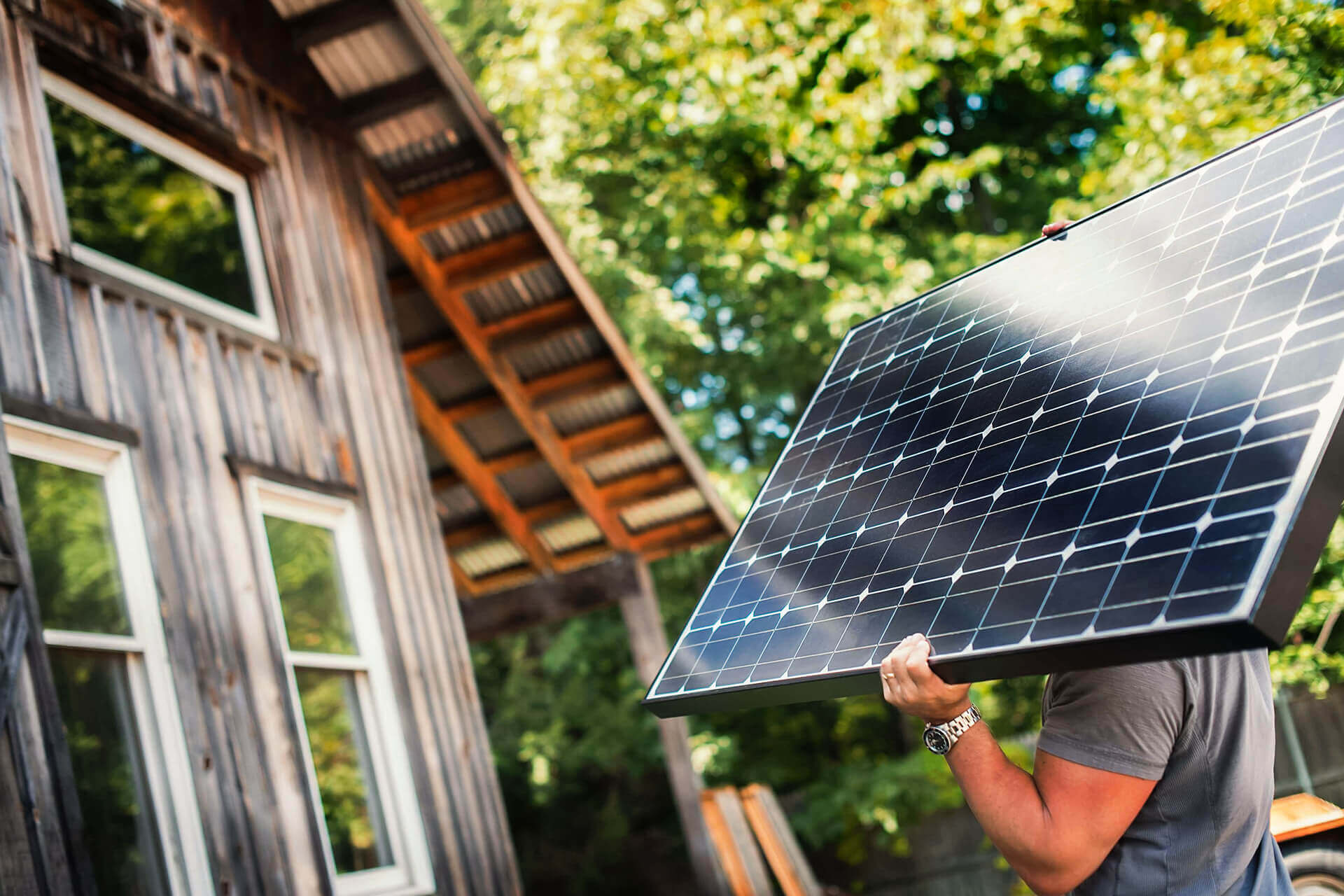 Ein Mann mit einem Solar-Panel auf einer grünen Baustelle