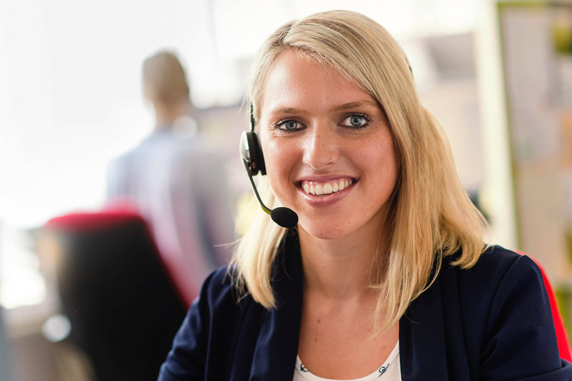 Kundenservice-Beraterin von energie schwaben mit Headset berät einen Kunden am Telefon.